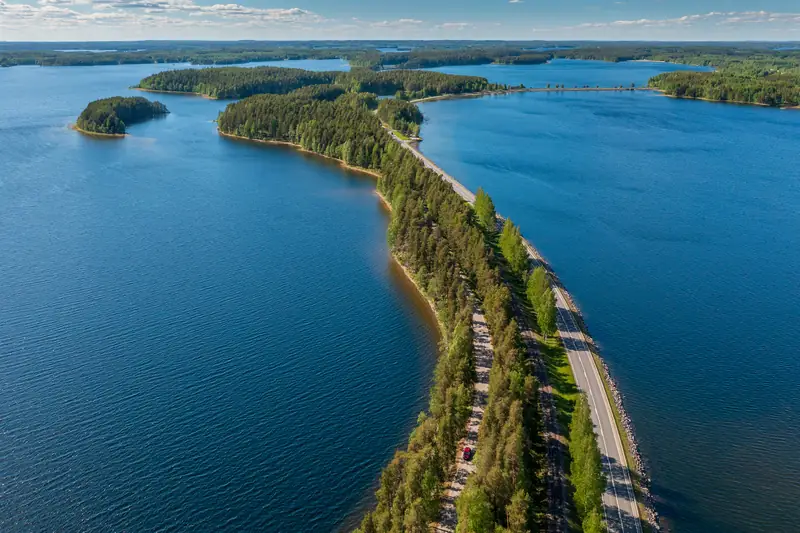 Ilmakuva kapeasta metsäisestä selänteestä kahden järven välissä, selännettä pitkin kulkee tie.