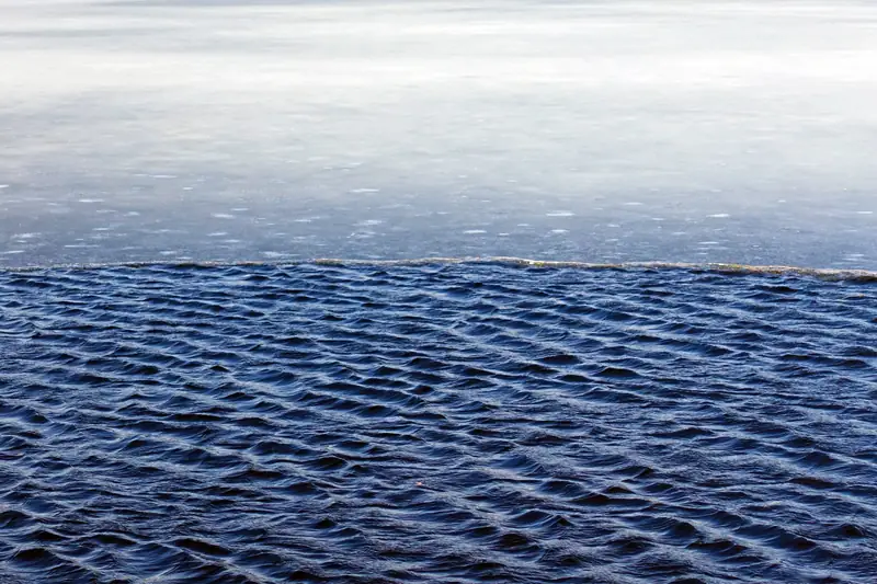 Jään reuna: yläosassa vaalea jää, alaosassa tumma, aaltoileva avovesi.