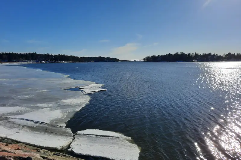 Rantakalliolta merelle: rannassa on vielä murtunutta jäälauttaa, ulompana avovettä.